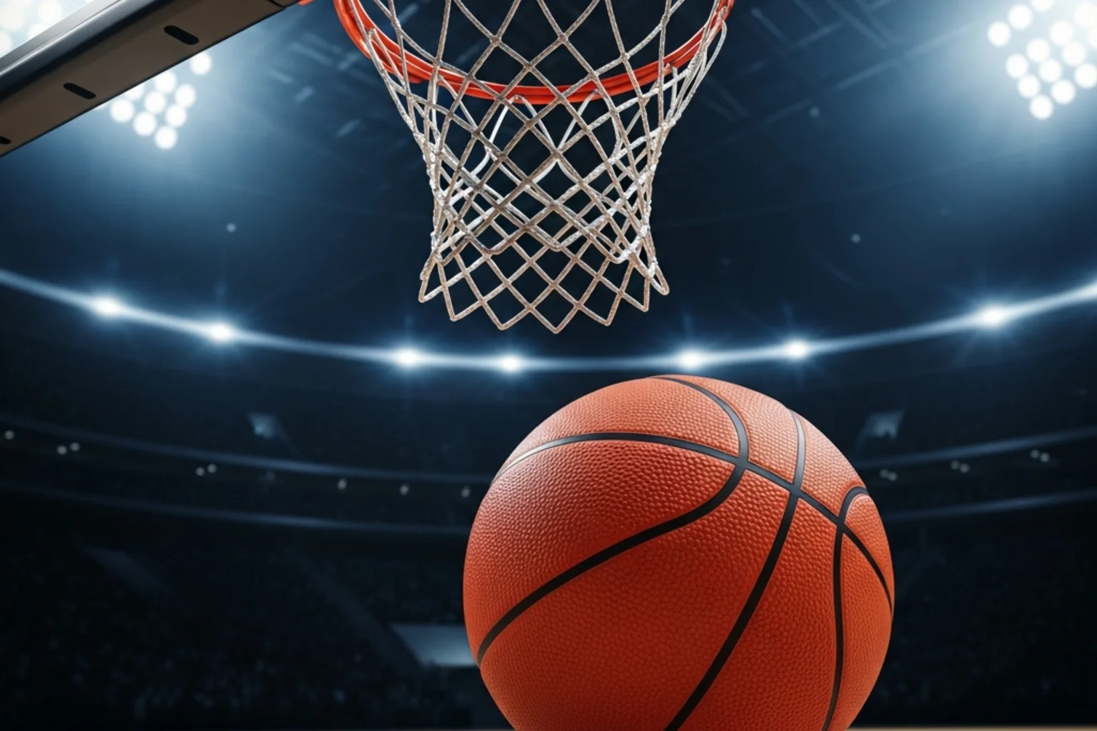 Bola de basquetebol laranja junto ao cesto num pavilhão desportivo